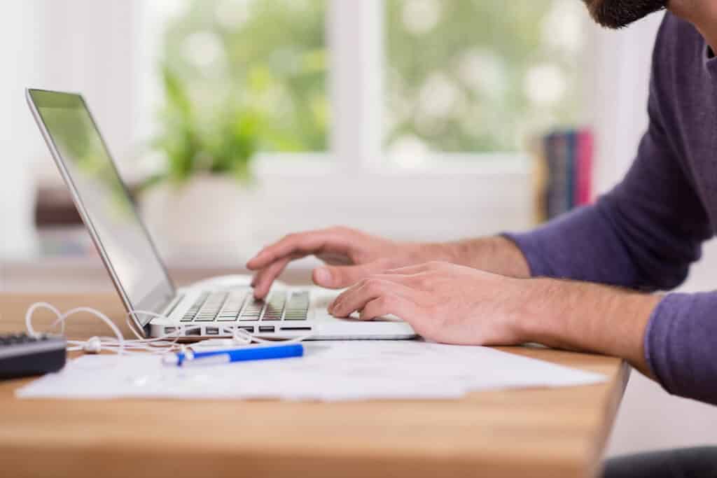 Surfire ways to get your budget on track - pictured man in front of labtop on desk