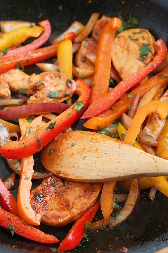 Cooking chicken and peppers in skillet