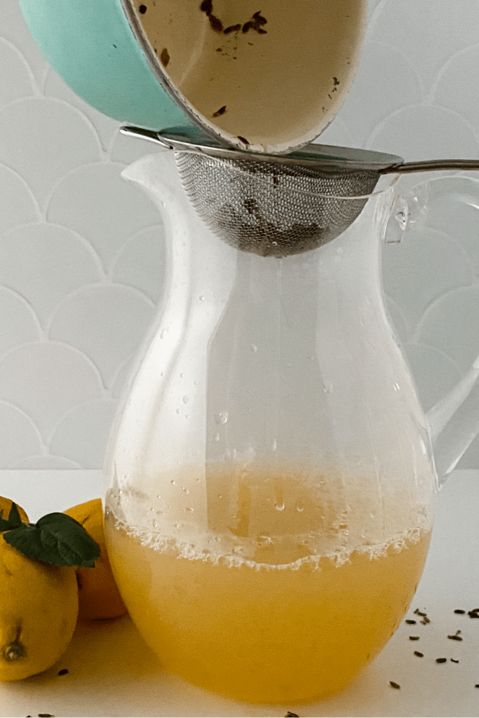 Straining lavender out of liquid into plastic pitcher