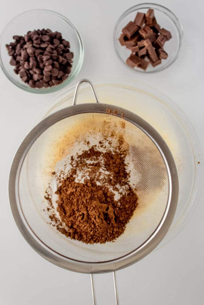 Adding in sifted cocoa powder