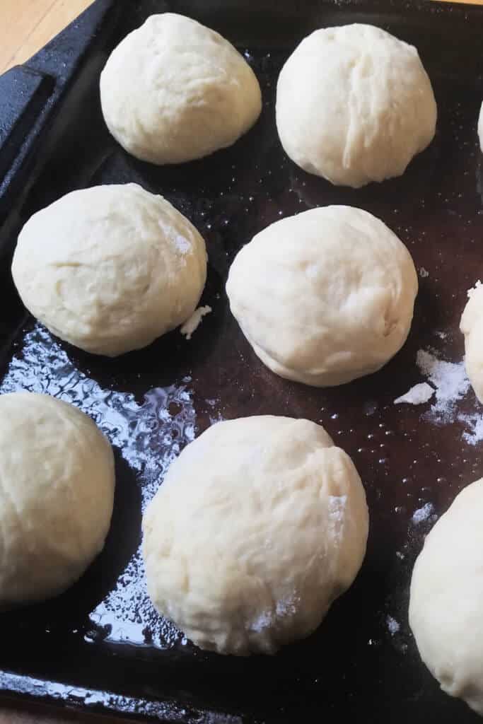 Dough balls on dark baking pan