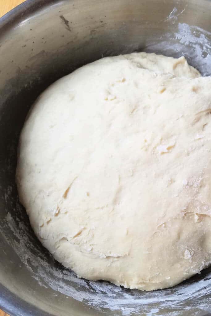 proofed dough in silver bowl with flour