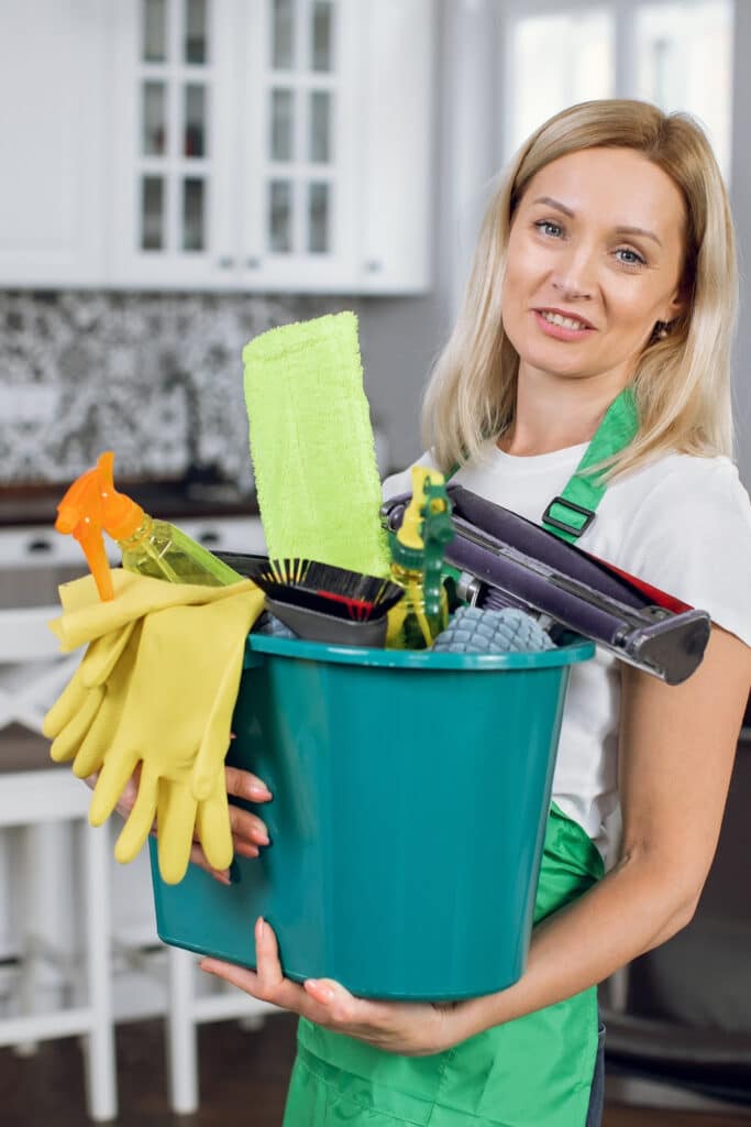 The right cleaning tools - woman holding up cleaning tools in hand