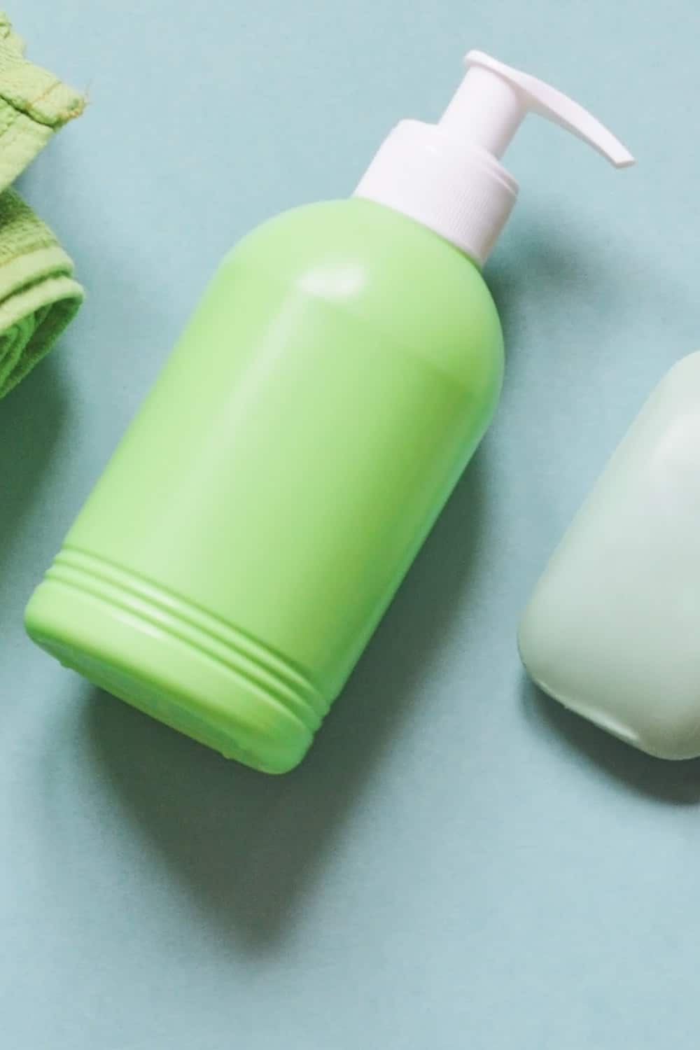 Green pump bottle for shower gel on blue background