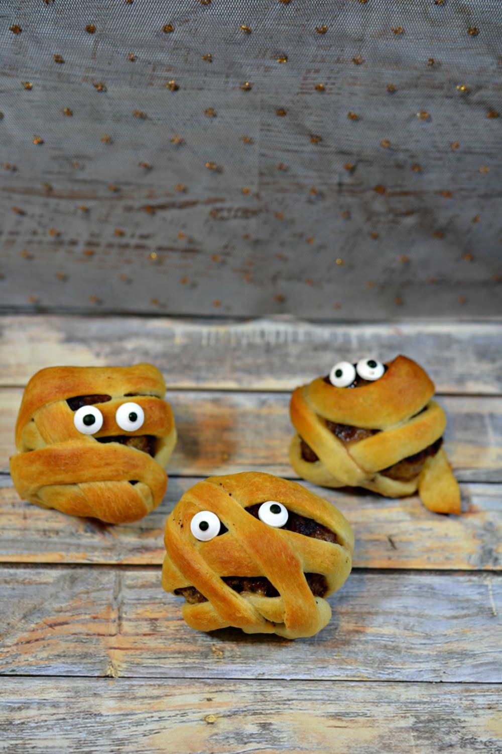 Mummy meatballs (three) on wooden background