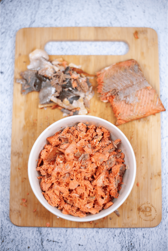 shredding salmon. shredded salmon in white mixing bowl