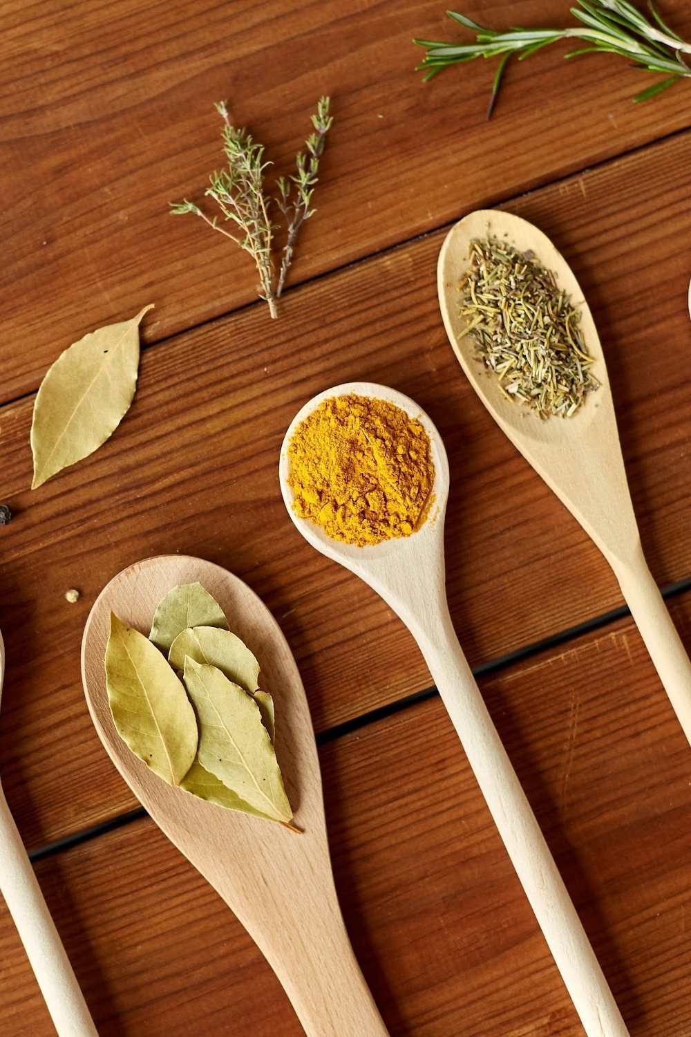 storing spices and herbs - pictured different dried herbs on wooden spoons