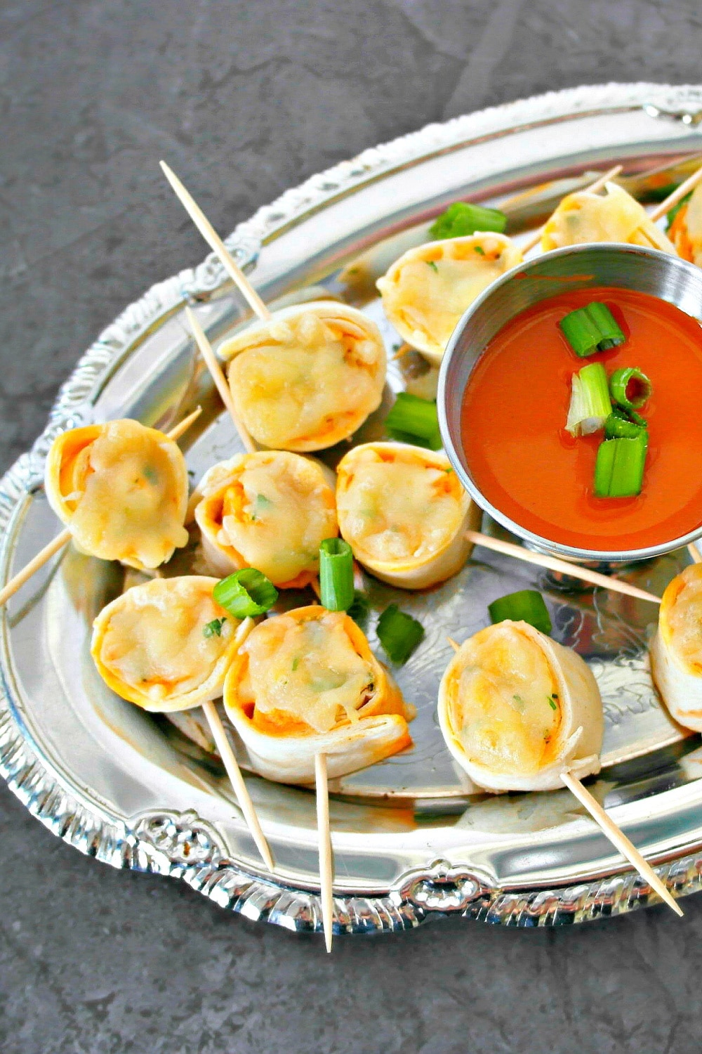 cheesy buffalo pinwheels on silver tray with dipping sauce