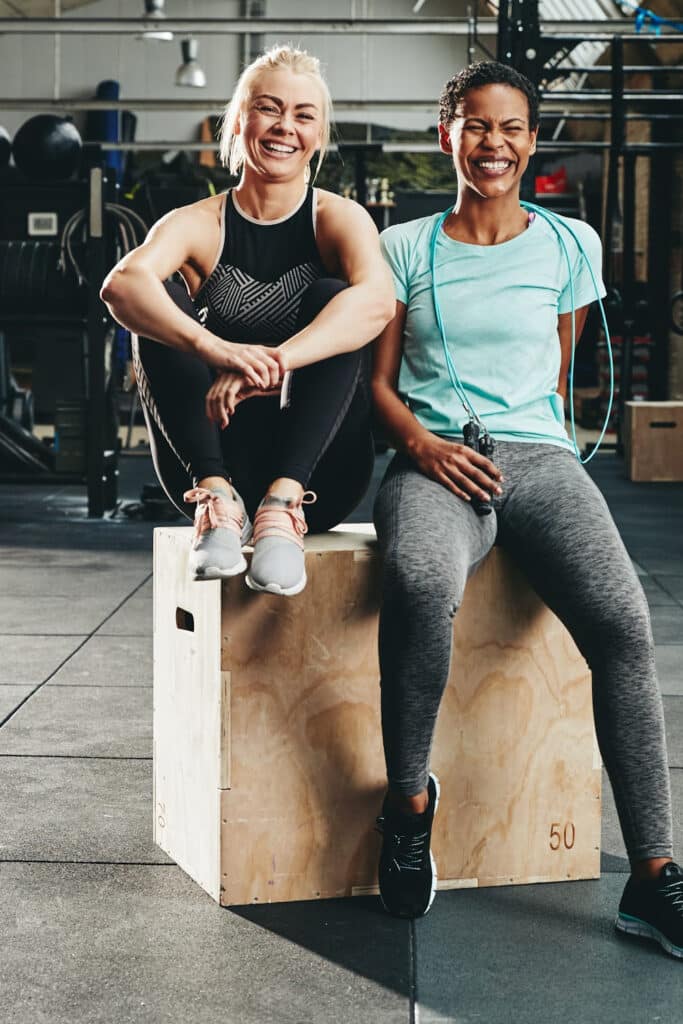 having a workout buddy - two women in gym