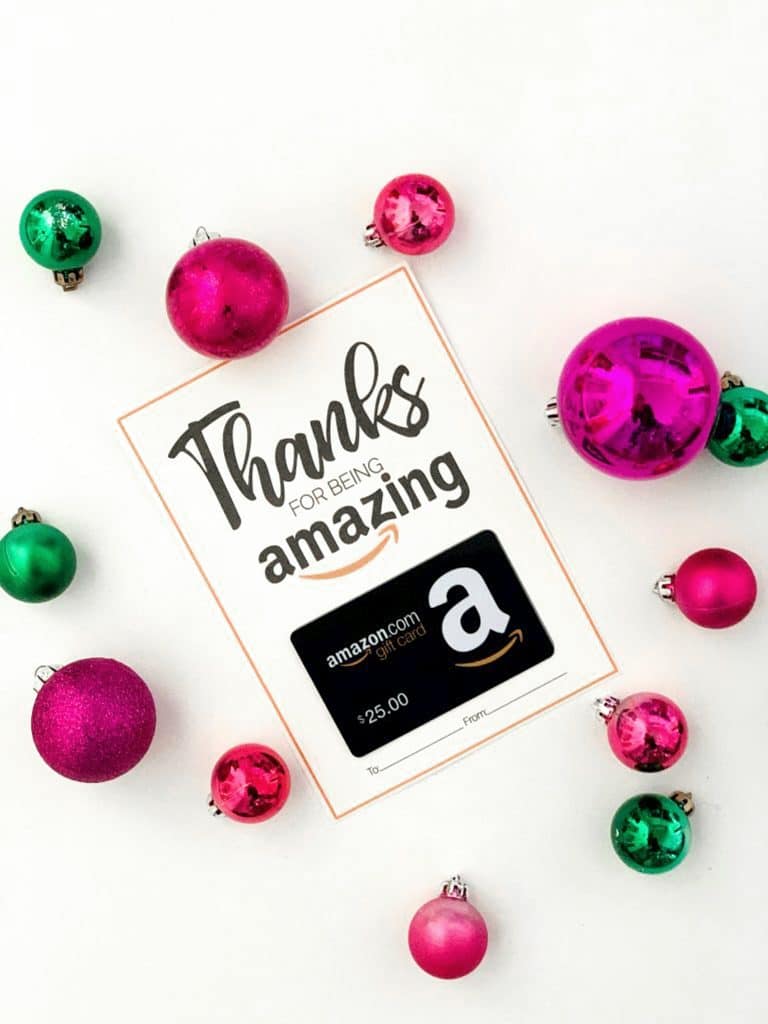 JustPosted AmazonCard pictured on white backgroundw ith red and green Christmas Ornaments