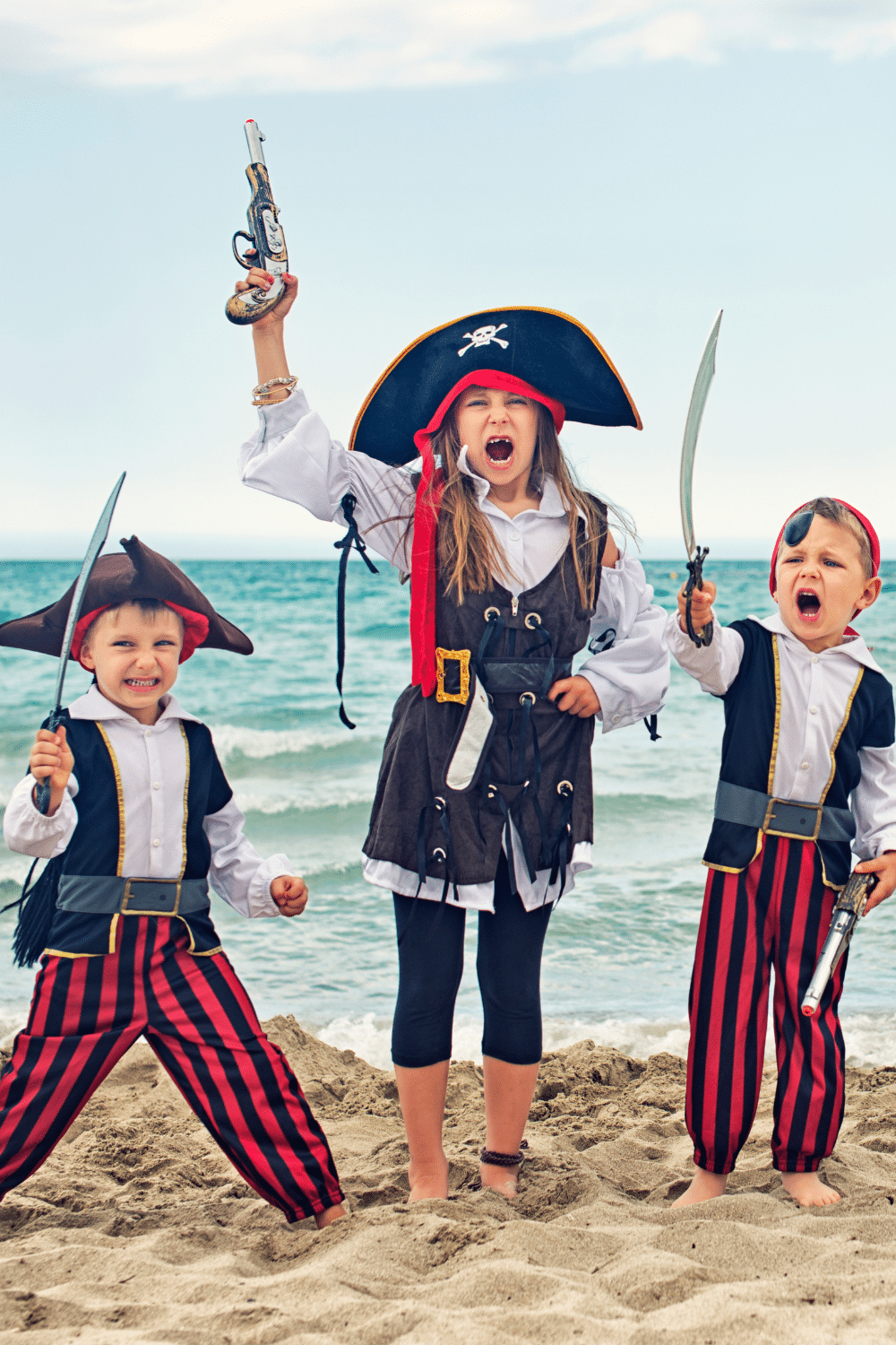 Three kids on beach dressed up like pirates. Talk like a pirate day.