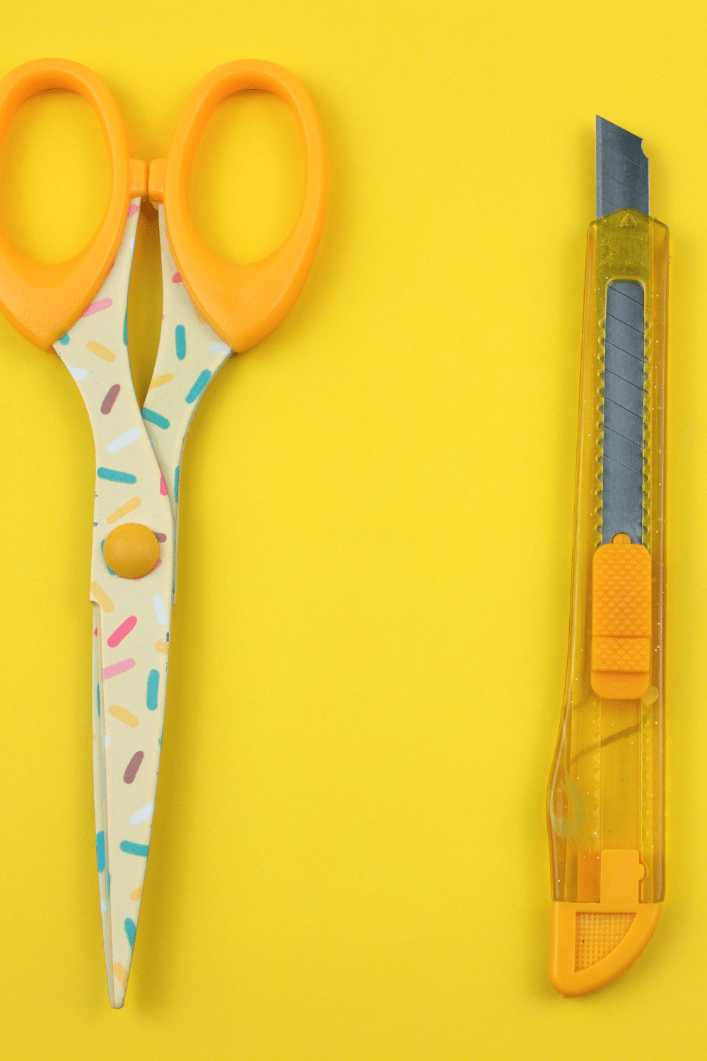 Using a box cutter to craft a DIY project pictured scissor and box cutter